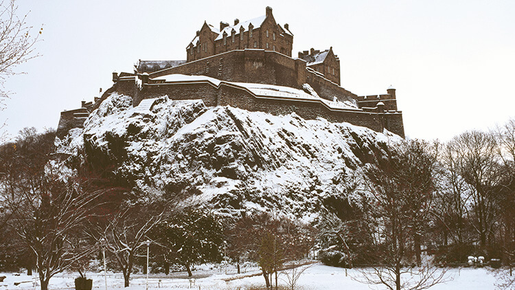 Il castello di Edimburgo innevato dai giardini di Princes Street