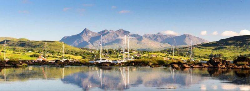 bahia-portree-montañas-cuillin-isla-skye-escocia Vista della baia di Portree con le montagne Cuillin sullo sfondo, nell'Isola di Skye, Scozia